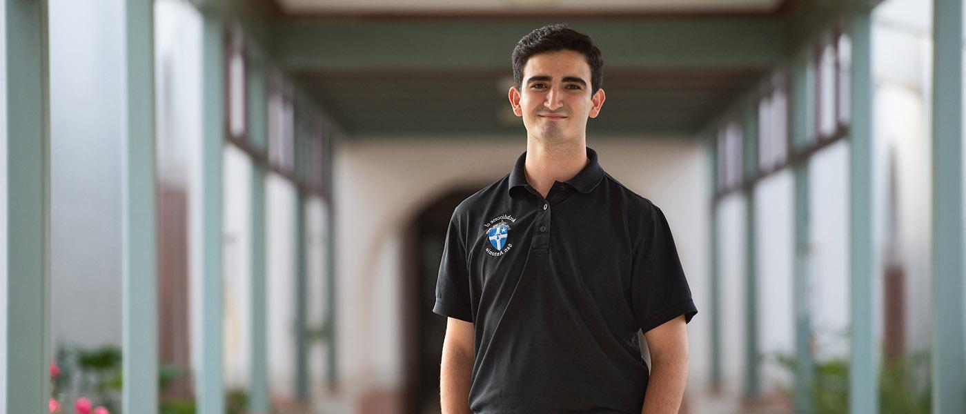 Pastoral Ministry student standing in an outdoor hallway.